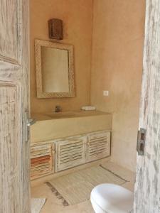 y baño con lavabo, aseo y espejo. en Mwezi - Maisha Resort, en Watamu