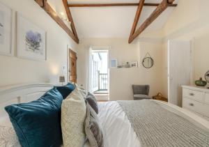 um quarto com uma cama branca e almofadas azuis em Ferrymans Cottage em Appledore