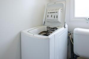a white washing machine in a bathroom next to a toilet at Mobilhome tout confort in Saint-Jean-de-Monts
