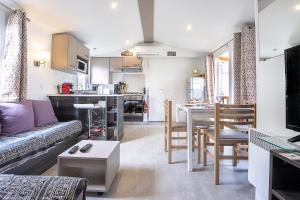 a living room with a couch and a table and a kitchen at Mobilhome tout confort in Saint-Jean-de-Monts
