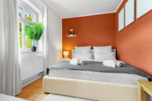 een slaapkamer met een groot bed met een oranje muur bij Stilvolles Apartment mit Festungsblick im Zentrum in Königstein an der Elbe