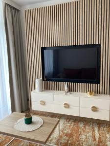 a living room with a large television on a dresser at BEL MARE 2 F207 in Międzyzdroje