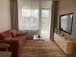 a living room with a red couch and a tv at BEL MARE 2 F207 in Międzyzdroje