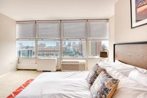 a bedroom with a bed with a view of a city at CozySuites 800 Tower 1BR w sky pool, gym! 18 in Louisville