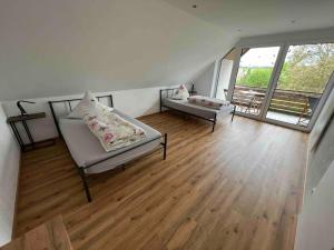 ein Wohnzimmer mit 2 Betten und einem großen Fenster in der Unterkunft Ferienwohnung Saumpfad 25 Min ins Legoland in Horgau
