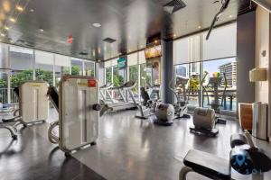 a gym with cardio equipment in a large room with windows at To Steps from the Beach - Coastal Bliss, Pool- Gym in Hallandale Beach