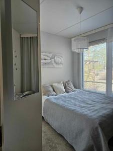 een slaapkamer met een bed, een spiegel en een raam bij Uniq Home Helsinki in Helsinki