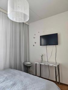 a bedroom with a bed and a tv on the wall at Uniq Home Helsinki in Helsinki