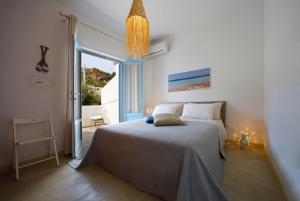 a bedroom with a bed and a large window at Villetta Acacie in San Vito lo Capo