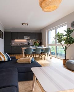 een woonkamer met een blauwe bank en een tafel bij Moderne & Familienfreundliche Ferienwohnung am Goitzschesee in Pouch