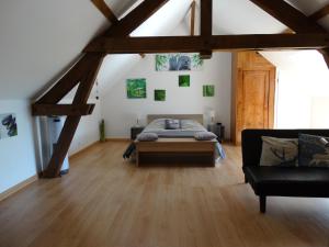 um quarto com uma cama e um sofá num quarto em Aux Champs Des Châteaux em Sambin