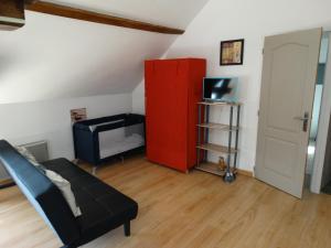 uma sala de estar com um armário vermelho e um sofá em Aux Champs Des Châteaux em Sambin