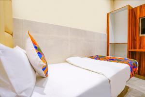 um quarto com 2 camas e um espelho em FabExpress Emirates Suits em Mumbai