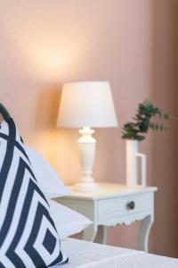a bed with a white lamp on a white table at Old Town Bonbonniere in Bordighera +15 photos