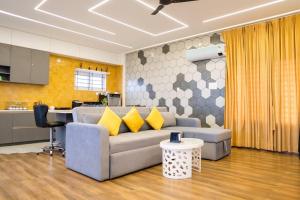 a living room with a gray couch with yellow pillows at Bumblebee - The Penthouse in Mysore
