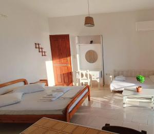 a living room with two beds and a table at Enjoy sunset from a wonderful traditional studio-Melina in Ioulis