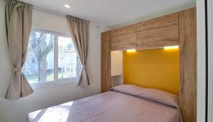 1 dormitorio con cama y ventana en Romea Family Camping, en Casal Borsetti