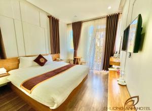 una camera con un grande letto e una televisione di Phương Anh Valley Hotel a Da Lat
