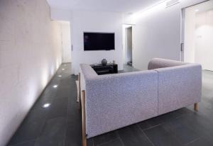 Ampersand - Bright 2-Bedroom Apartment في برشلونة: غرفة معيشة مع أريكة وتلفزيون