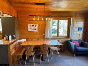 une salle à manger avec une table en bois et un canapé bleu dans l'établissement Chalet Claire, à Bürchen