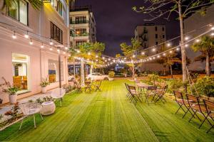 a patio with chairs and tables and lights at Melanta Hotel - FLC Sầm Sơn in Sầm Sơn