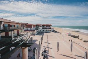 オスゴールにあるHôtel de La Plageの建物と海を望むビーチの景色を望めます。