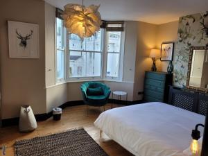 sypialnia z łóżkiem, krzesłem i oknem w obiekcie *Leamington Apartments* - George St - 3 bedroom townhouse w mieście Leamington Spa