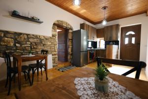 a kitchen and dining room with a table and a refrigerator at Villa Shpiragu Village Experience in Berat