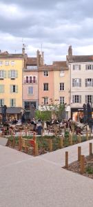 a group of buildings with tables in front of them at Studio centre Macon place aux herbes in Mâcon