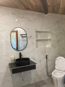 baño con espejo y aseo en Cát Tiên Hotel, en Cát Tiên