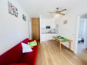 - un salon avec un canapé rouge et une table dans l'établissement Appartamento Stella, à Bibione