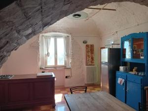 eine Küche mit einem Tisch, einem Kühlschrank und einem Fenster in der Unterkunft B&B Il Secolo Breve in Ortona