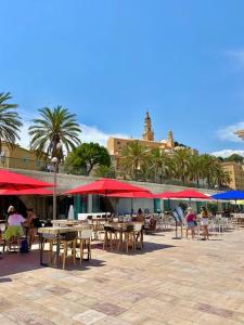 a patio with tables and chairs and umbrellas at Le St Julien Terrasse vue mer exceptionnelle in Menton