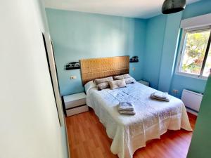 een slaapkamer met een bed met blauwe muren bij Miramar 22 in Almuñécar +17 foto's