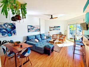 een woonkamer met een blauwe bank en een tafel bij Miramar 22 in Almuñécar