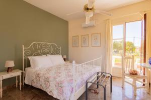 1 dormitorio con cama blanca y ventana en Villehardouin Farm Estate, Studios & Apartments, Minia, Kefalonia, en Argostoli