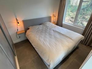 a small bed in a room with two lamps at Prachtige vakantiewoning aan zee in Ouddorp