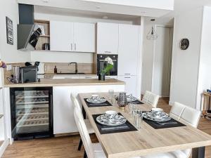 a kitchen with a wooden table with chairs and a dining room at Le Lodge - Bleu lavande in Le Meux