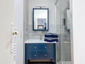 een badkamer met een blauwe wastafel en een douche bij Le Lodge - Bleu lavande in Le Meux