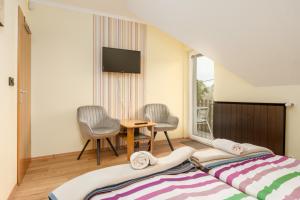 a bedroom with a bed and a table and chairs at Janika Pension in Vonyarcvashegy