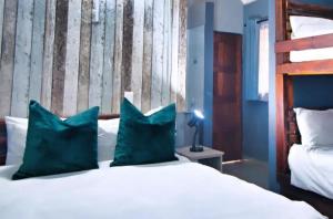 a bedroom with a bed with two blue pillows at Ndalo Lodge Mbombela in Nelspruit
