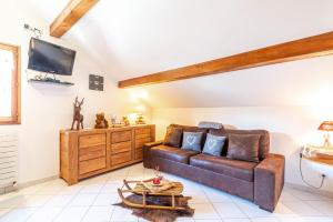 a living room with a couch and a tv at Smartstay au reve Savoyard - Studio N-6 in Morillon