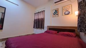 a bedroom with a bed with a red blanket at Laxmi Niwas, Salt Lake, Kolkata, 10mins from Sector 5 in Kolkata