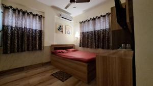 a bedroom with a bed with red sheets and curtains at Laxmi Niwas, Salt Lake, Kolkata, 10mins from Sector 5 in Kolkata