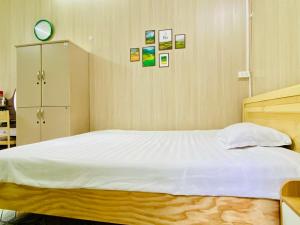 Un dormitorio con una cama grande con sábanas blancas. en Cozy Homestay with Large bed, private bathroom, large Balcony, en Hanói