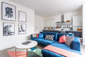 a living room with a blue couch and a table at 2 Bedroom Apartments with Sofa bed in Southend in Southend-on-Sea