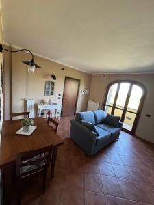 a living room with a blue couch and a table at CS Holiday in Castelnuovo Berardenga