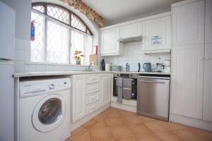 a kitchen with a washing machine and a window at Forest Park in Courtown