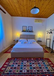 a bedroom with a bed and a rug on the floor at Nika's Guest House in Berat