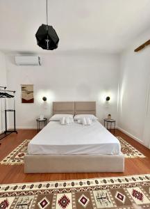 um quarto com uma grande cama branca e 2 almofadas em Nika's Guest House em Berat